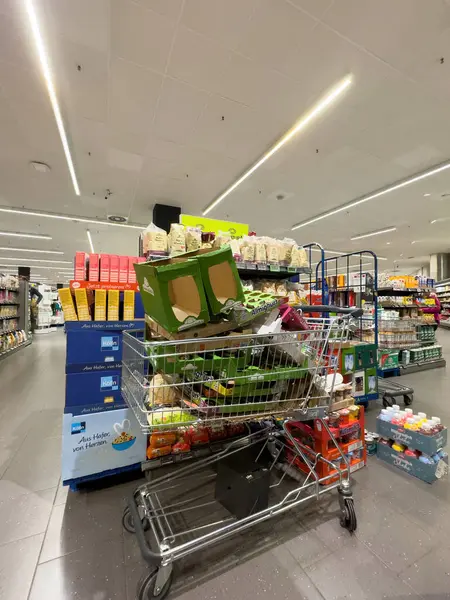 ドイツ 2023 スーパーマーケットのカートには段ボールパッケージが搭載され 店員が棚を配置する過程で捕獲されます — ストック写真