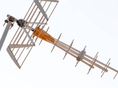 Düşük açılı bir perspektiften yakalanan, çelik bileşenler içeren bir anten ve farklı bir sarı plastik bölüm, hem analog hem de dijital sinyaller almada başarılı olur.