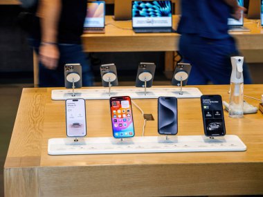 Paris, Fransa - 22 Eylül 2023: Müşteri siluetleri ve Apple personeli iPhone 15 'in Max Pro sergilendiği bir dizi Apple bilgisayarının arkasında dolaşıyorlar