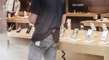 Paris, Fransa - 22 Eylül 2023: Müşteriler ve Apple personeli, iPhone 15 Pro Max 'in sahne aldığı son teknoloji Apple bilgisayar kurulumlarının arka planında geziniyorlar..