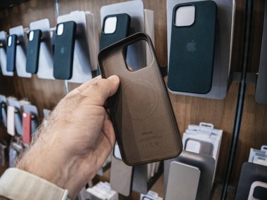 Paris, Fransa - 22 Eylül 2023: Elma iPhone 15 Pro için iyi hazırlanmış bir koruyucu dava, satın alma veya almamaya karar vermede kilit rol oynayan anlayışlı bir erkek müşterinin elinde..