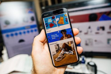 Paris, Fransa - 12 Temmuz 2023: Erkek el en son iPhone Pro 'yu ustalıkla tutuyor, Prime Day Özel Fiyatları içeren Amazonların uygulamasını sergiliyor, hevesli tüketiciler için gün boyu yapılan anlaşmaları gösteriyor.