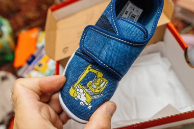 Erkek el ele tutuşan çocuk ayakkabıları nakışlı bir kazı makinesi tasarımı.