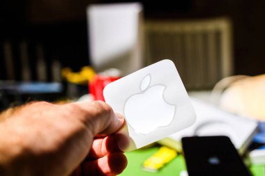 Londra, İngiltere - 28 Eylül 2023: Son teknoloji iPhone 15 Pro 'nun ilk kurulumu ve açılışı sırasında, bir el gururla ikonik Apple Bilgisayarlarının logo etiketini gösteriyor.