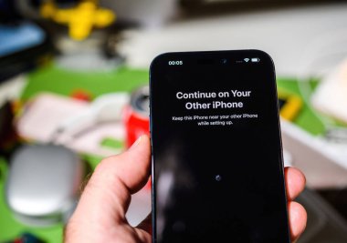Londra, İngiltere - Sep 28, 2023: iPhone 15 Pro akıllı telefonunun kurulum süreci sırasında, başka bir iPhone üzerinde devam etmek için bir komut, bu yüzden her iki aygıtı sorunsuz bir deneyim için elinizin altında tutun