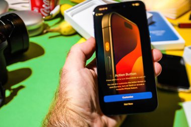 Londra, İngiltere - 28 Eylül 2023: Londra, İngiltere - 25 Eylül 2023: Yeni titanyum iPhone 15 Pro 'daki Action düğmesiyle etkileşime giren bir erkeğin yakın çekimi - ilk telefon kurulumu