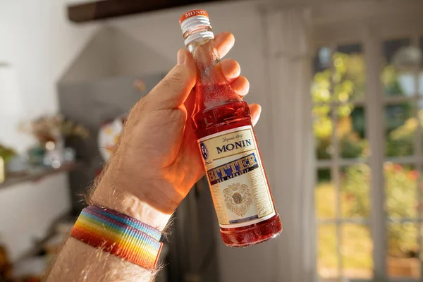 フランス 2023 男性の手 モニン食前酒のボトルは シロップに特化したフランスの会社の焦点を当てた製品になります リキュール 商業のためのフルーツピューレ — ストック写真
