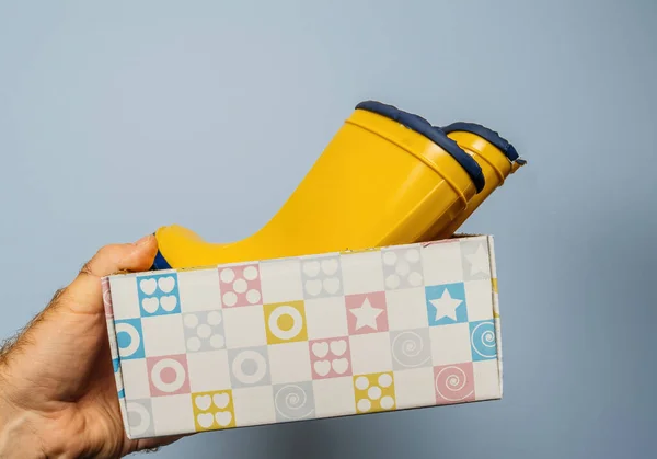 Eine Männliche Hand Präsentiert Ein Sorgfältig Verpacktes Paar Gelber Stiefel — Stockfoto