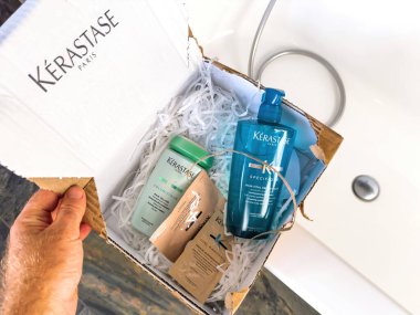 Paris, France - Sep 28, 2023: unboxing of Kerastases premium shampoos, Specifique and Volumifique, delivered in a branded cardboard box by the renowned French shampoo manufacturer clipart