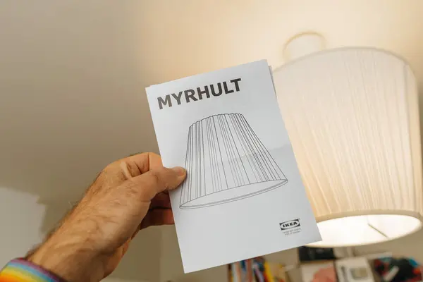 2023年10月30日 法国巴黎 一张从Ikea拍摄的男性手握着Myrhult天花板灯说明书的视点图片 上面可以看到已安装的灯 — 图库照片