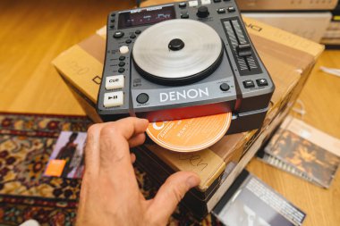 Paris, Fransa - 24 Ekim 2023: Yeni Denon Profesyonel DN-S1000 DJ karıştırma güvertesi denetleyicisine bir CD yerleştirirken görüldü.