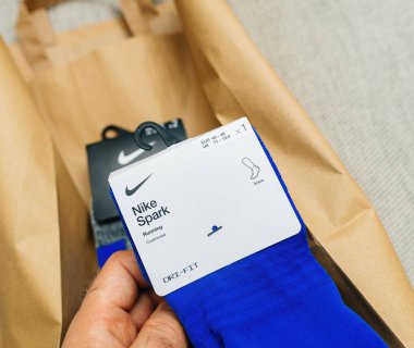 Paris, Fransa - 25 Ekim 2023: Meraklı bir erkek bakış açısına göre, bir el, nemlendirici Dri-FIT teknolojisine sahip yeni bir çift Nike Spark koşu çorabı tutuyor.