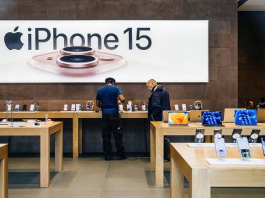 Paris, Fransa - 22 Eylül 2023: Bir Apple mağazasındaki müşteriler yeni iPhone 15 Pro ile taze reklamların ışıltısı altında karşılaşırken yakalandılar