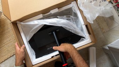 Paris, Fransa - 22 Eylül 2023: Lenovo Düşünce İstasyonu monitörünün kenarını güvenli bir şekilde tutan bir erkeğin yukarıdan aşağıya bakış açısı, profesyonel yönelimi simgeliyor.