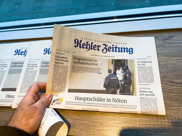 Frankfurt, Germany - Jan 25, 2023: A photo within Mittelbadische Presse shows police action in a German cafe, reflecting societal issues and the role of law enforcement in public safety