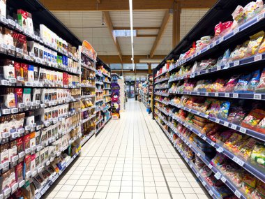 Paris, Fransa - 10 Kasım 2023: Büyük bir süpermarket koridorunun perspektifi, fayanslı zemin ve bir çok seçenekle karakterize edilmiş birden fazla çikolata ve şekerle dolu