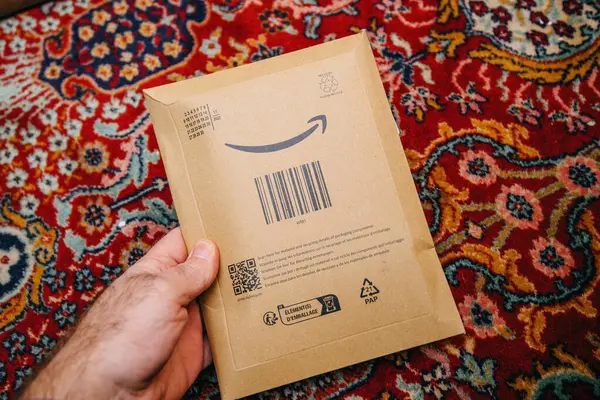 フランス 12月 2023 配信されたAmazon Prime小包を保持する男性の手のPov 象徴的な笑顔の矢印ロゴタイプをフィーチャー 信頼性の高い配信を象徴しています — ストック写真