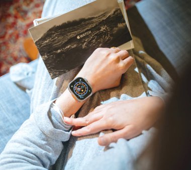 Londra, Birleşik Krallık - 28 Şubat 2022: Meraklı bir kadın yeni Apple Watch Ultra 2 'sinde zamanı kontrol ediyor, dayanıklılık sporları gibi ekstrem aktiviteler için tasarlandı, anı yakalıyor