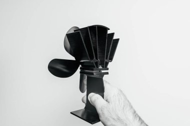 Isıyı odada daha etkin bir şekilde dağıtmak için tasarlanmış siyah, güçsüz bir soba vantilatörünün arka görüntüsü ısı algılamasını güçlendirir.