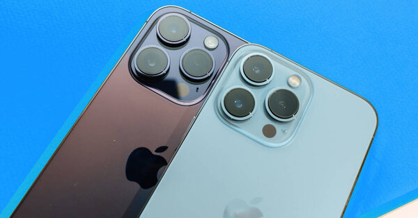 Paris, France - Sep 29, 2022: Two luxury Apple iPhone models displayed side by side against a blue background, featuring prominent logotypes and professional camera modules.