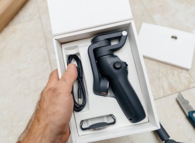 Yeni bir cep telefonu dengeleyicisini bir kutuda tutan bir erkeğin net bir görüntüsü.