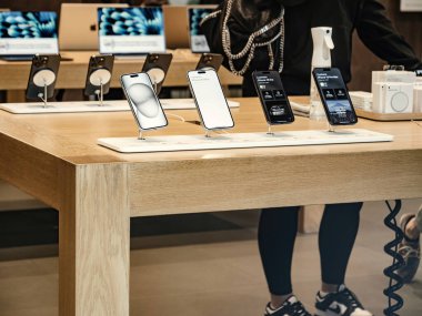Paris, Fransa - 22 Eylül 2023: Bir müşteri yüksek enerjili fırlatma günü boyunca bir Apple mağazasının hareketli ortamında iPhone 15 Pro sürümünü araştırıyor.