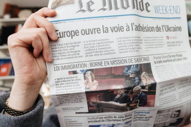 Frankfurt, Almanya - 20 Aralık 2023: Bir şahıs, Le Monde hafta sonu gazetesini okumaya dalmış ve dijital ortamda basılı medyanın kalıcı önemini vurgulamıştır.