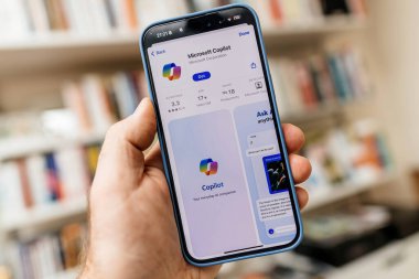 Kaliforniya, ABD - 21 Ocak 2024: Birinci şahıs bakış açısına göre, bir erkek eli en son iPhone 15 Pro 'yu App Store ile birlikte Microsoft Copilot App, Microsoft tarafından geliştirilen bir sohbet robotu olan