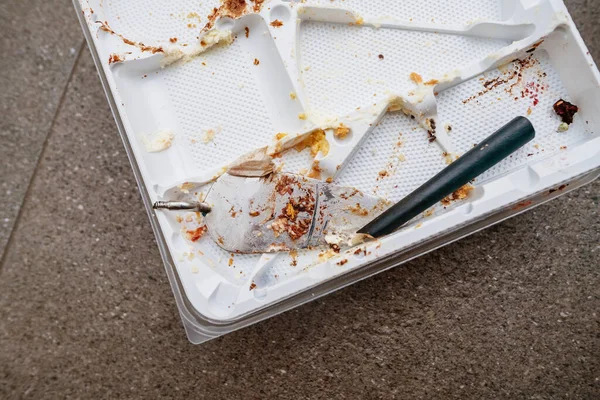 壊れたスパチュラのトップダウンビューとパン粉が散らばった空のプラスチック製のケーキトレイ — ストック写真