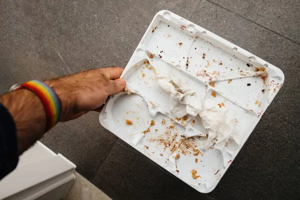 Male Hand Holds Empty Plastic Cake Tray Stone Background Showcasing — Stock Photo, Image