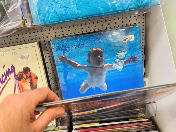 2024年1月18日 德国柏林 一个男子伸出手来购买标志性的Nirvana Nevermind Cd的Pov镜头 其特点是一个婴儿浮出水面赚钱 价格为22 99欧元 — 图库照片