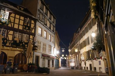 Gece gökyüzünün altında, yıldız şeklinde süslemeleri olan boş kaldırım taşı caddesi.