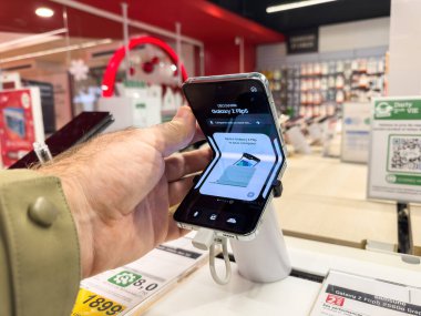 Strasbourg, France - Dec 7 2023: Male hand holds Samsung foldable phone, priced at 1899 euros, epitomizing modern tech innovation and style clipart