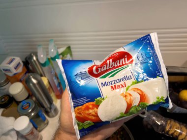 Paris, Fransa - 15 Mayıs 2022: Erkek elinde kremalı güzelliğin tadını çıkarmaya hazır Galbanis Mozzarella Maxi paketi var.