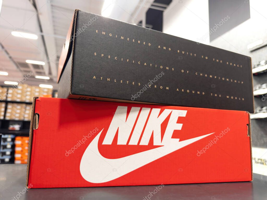 France - Oct 12, 2023: Nikes iconic shoes, neatly packaged in vibrant red cardboard, as shoppers browse for new footwear. Above, another box proudly displays slogans