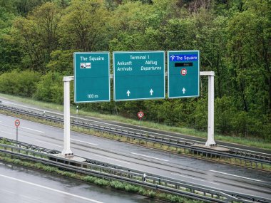 Alman Autobahn 'ının üzerinde bir yön işaretinin havadan görünüşü, yolculara Squaire, Terminal 1 geliş ve gidiş gibi yerlere rehberlik ederek, sürücülerin 70 kmh' lik pürüzsüz bir navigasyon sağlamaktadır.
