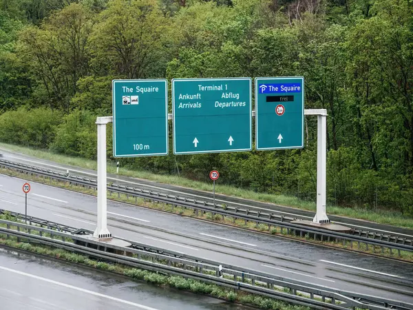从空中俯瞰德国高速公路上方的一个方向标志 引导游客前往诸如斯奎尔 一号航站楼到达和离开等目的地 确保驾车者航行通畅 时速70公里 — 图库照片