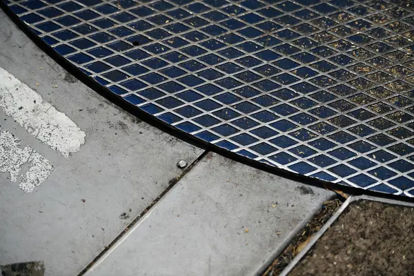 コンクリート テクスチャ パターンに対する金属グレートのクローズアップ — ストック写真
