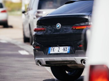 Haguenau France - 20 Mart 2024: Bir BMW X SUV, dinamik manevrasını ve şık tasarımını sergileyen bir yoldan zarifçe sağa dönerken bir telefon görüntüsü yakalar.