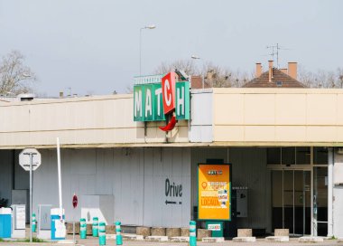 Haguenau, Fransa - 20 Mart 2024: Haguenau 'daki bir süpermarketin hareketli girişi, açık bir gökyüzü altında alışveriş yapanların girip çıkmadığını gösteriyor.