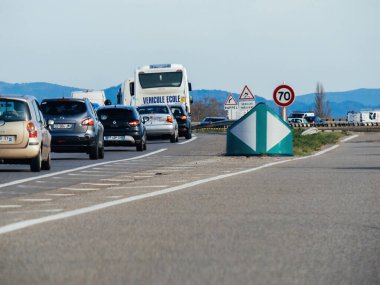 Strasbourg, Fransa - 20-2024 yılları arasında 70 km / h hız sınırı tabelası Fransız otobanını çeşitli markalardan çeşitli araçların arasında, yolu güvenle geçen bir okul otobüsü ile süsledi.