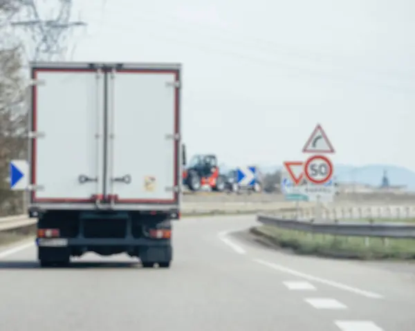 Rozkojarzona Perspektywa Rejestruje Poruszającą Się Ciężarówkę Drodze Obok Znaku Drogowego — Zdjęcie stockowe