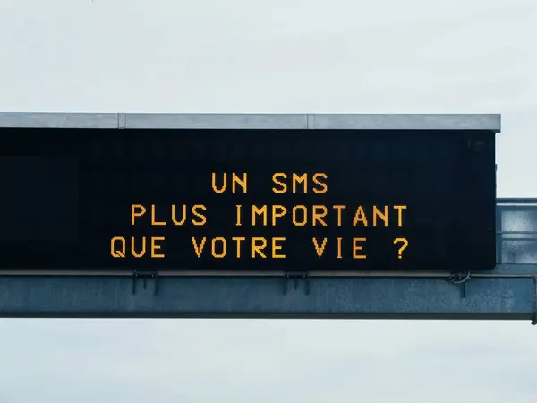 フランス語の高速道路上の注意サインは あなたの人生よりも重要なテキストメッセージです — ストック写真