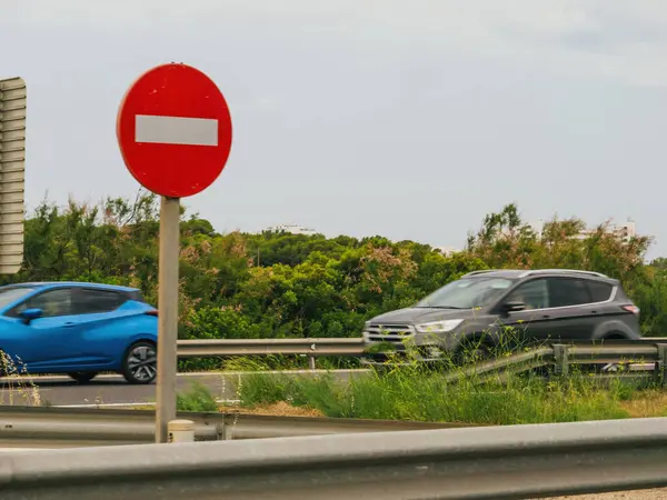 Een Blauwe Auto Rijdt Een Snelweg Langs Een Rood Verkeersbord Stockafbeelding