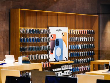 Strasbourg, Fransa - 23 Aralık 2023: Düzenli bir Apple Watch aksesuar ve MagSafe vakası organize çeşitliliğin sergilendiği boş bir Apple mağazasının duvarını süslüyor