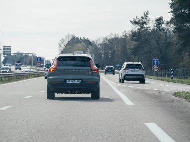 Fransa - 20-2024 arası: Bir dikiz manzarası, Fransız otoyolu boyunca giden bir Volvo SUV 'u yakalıyor, parlak tasarımı, zahmetsiz zarafet ve güç ile yolu dolaşırken manzarayla harmanlanıyor.