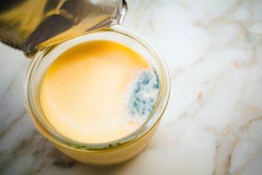 Bir muhallebi kavanozu küflenmeye yenik düştü. Çürük ile gölgelenen yüzey, besin korunmasının önemini gösteriyor.