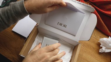 Paris, Fransa - 14 Sep 2023: Lüks bir mücevher kutusunun açılması sırasında erkek eller sofistike bir Dior kutusunu tutuyor