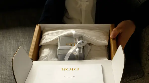 2023年9月14日 法国巴黎 一个女人兴奋地从纸盒中取出昂贵的基督教迪奥礼物 — 图库照片