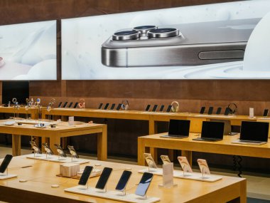 Paris, Fransa - 23 Aralık 2023: Elma bilgisayarları en son satıştaki titanyum iPhone, arka plandaki laptolarda multiupel mac cihazları olan titanyum smartpnhe ile elma stokçusu içinde reklam afişi